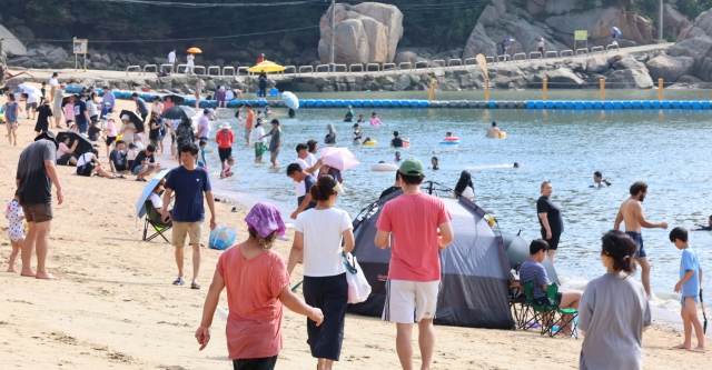 People enjoy their time at a beach in Incheon, west of Seoul, on Wednesday. (Yonhap)