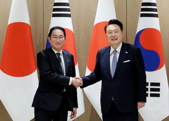 South Korean President Yoon Suk Yeol (right) poses with Japanese Prime Minister Fumio Kishida during their talks at the presidential office in Seoul on Friday. (Pool photo via Yonhap)