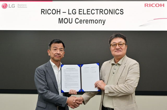 Paik Ki-mun (right), head of LG Electronics' information display business division, and Takahiro Irisa, president of digital services at Ricoh shake hands in a signing ceremony held at LG Science Park in Seoul's Gangseo District on Sept. 12. (LG Electronics)